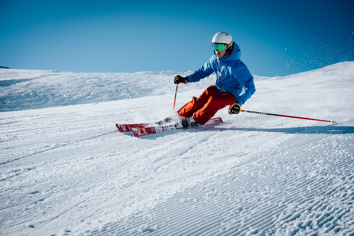 Skiers riding a chairlift above snowy trees